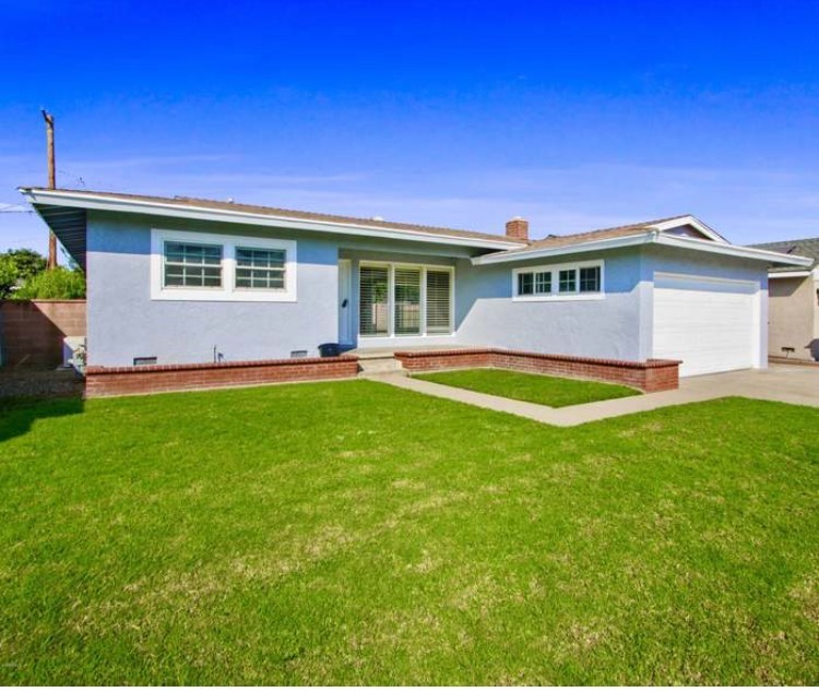 an image of the house’s front yard, featuring lush green grass.