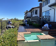 an image of workers working on the backyard of the house, with small pool