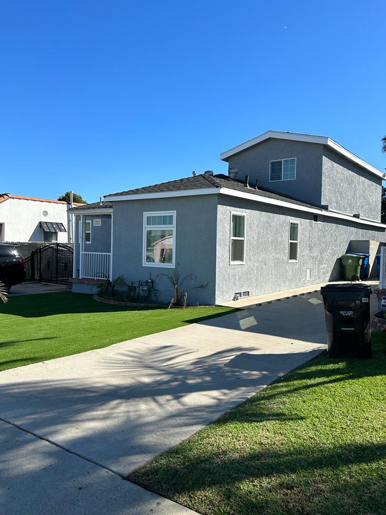 A picture of the frontyard of the house and  the sidewalk