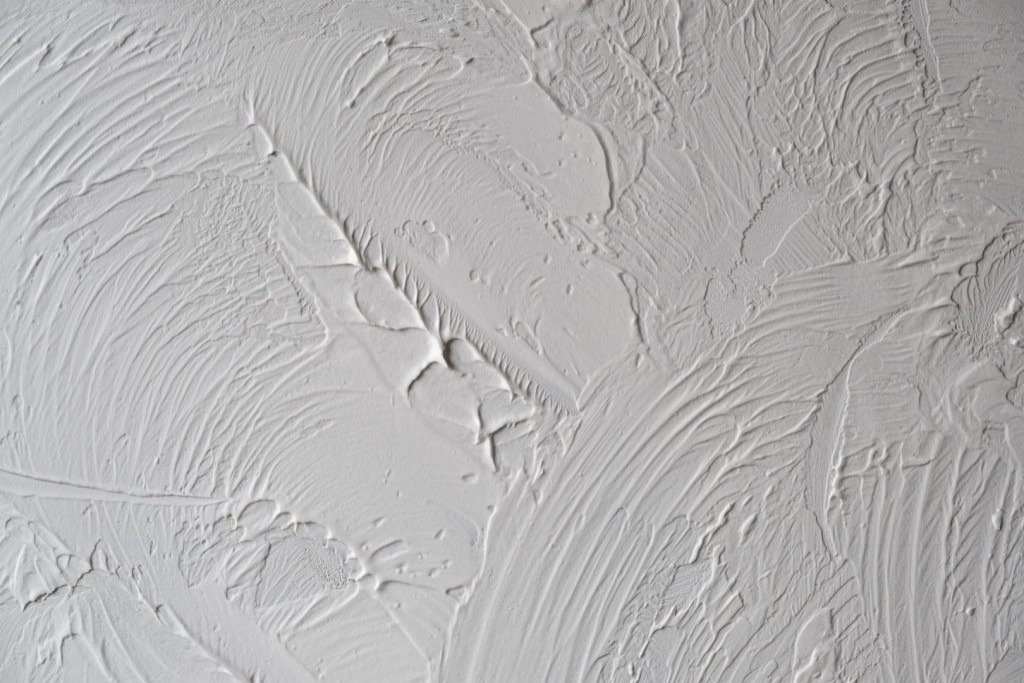 Close-up of textured drywall surface, showcasing abstract patterns created by drywall services.