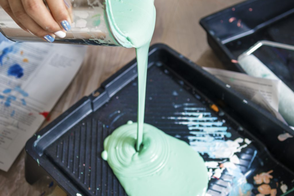Painter preparing high- quality elastomeric paint for stucco painting.