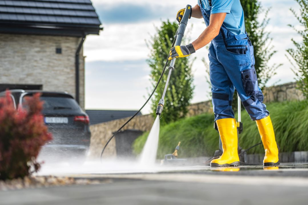 Pressure washing a driveway to remove dirt and grime.