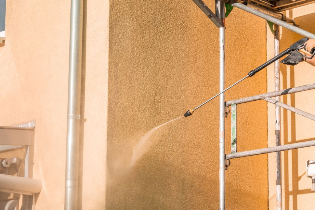 Pressure washing stucco to remove dirt before stucco painting.