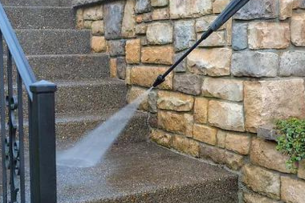 a person pressure washing stairs